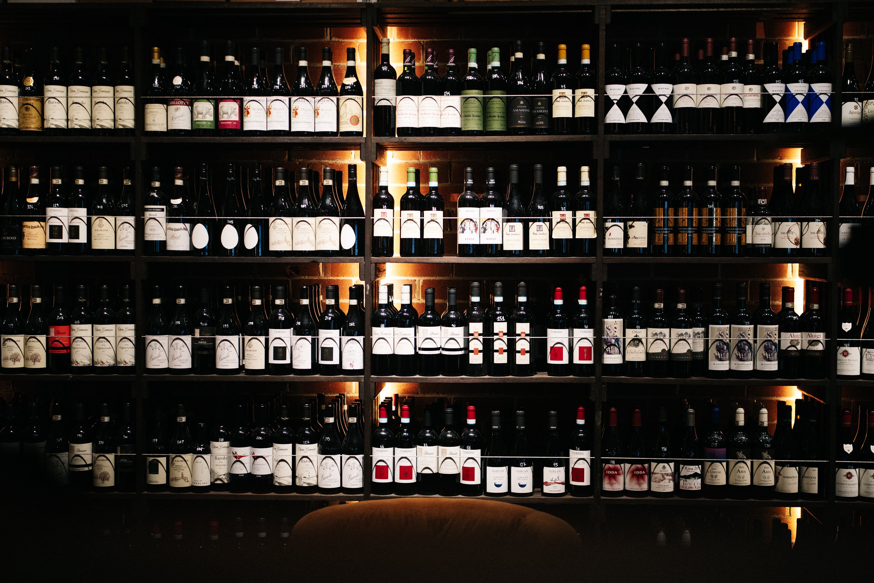Shelves filled with various bottles of wine in a dimly lit room.