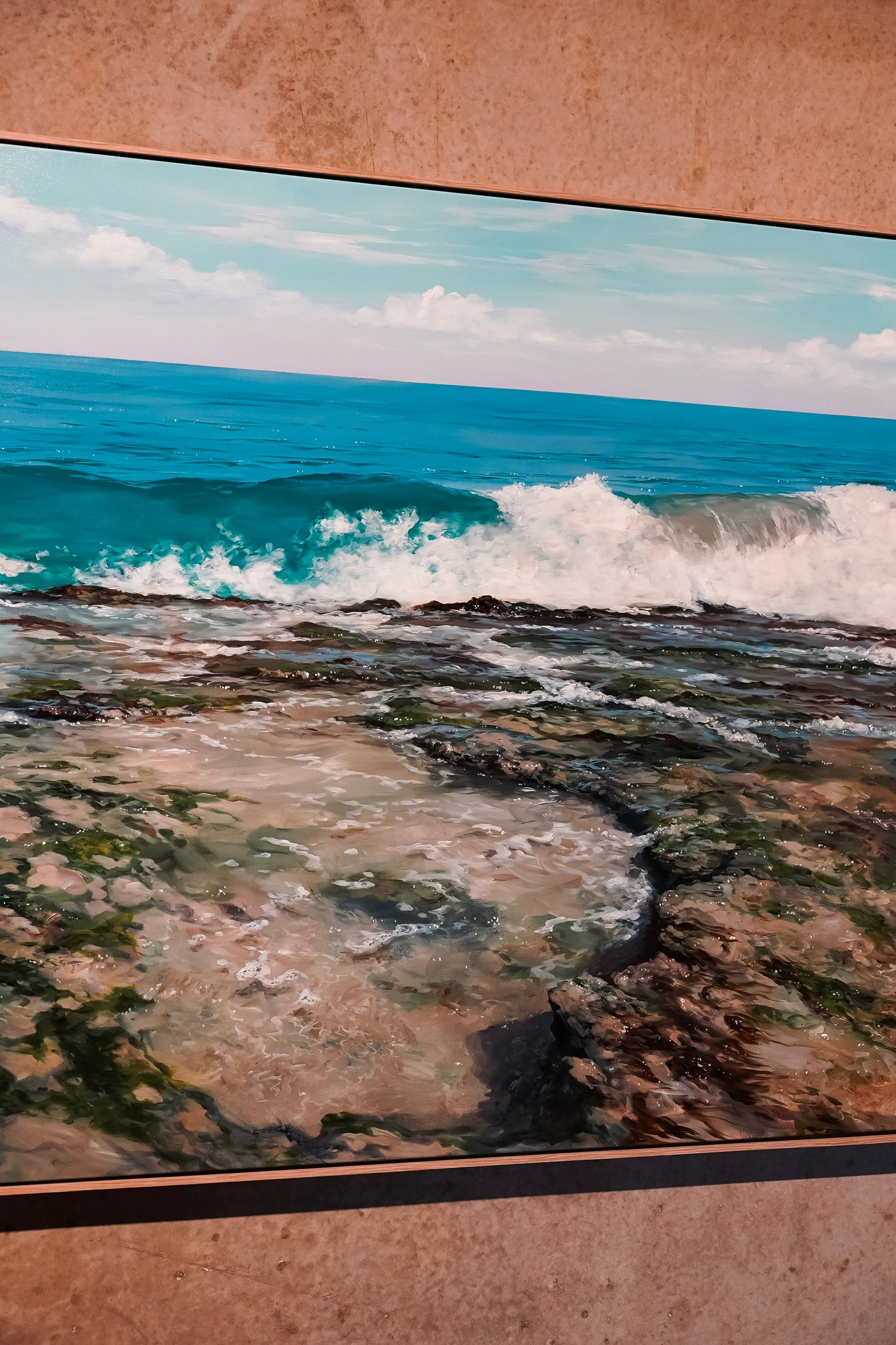 Ocean waves crashing against a rocky shore with a clear sky.