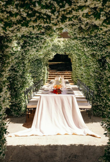 Dining table set under a floral archway