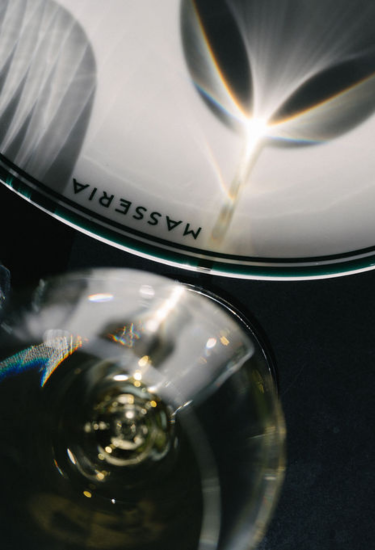 Close-up of a plate with 'Masseria' branding on a dark background