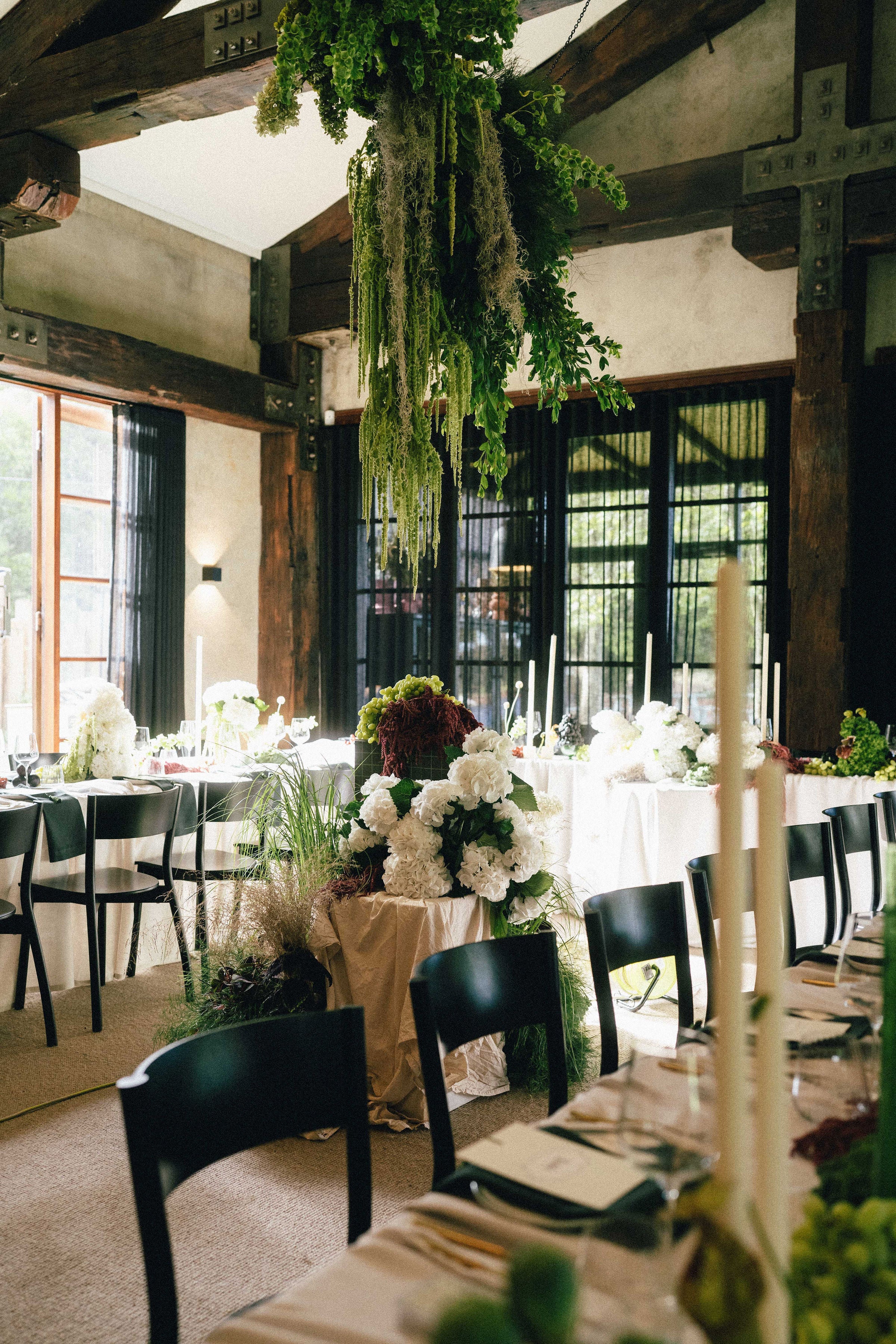 Decorative indoor setting with tables, chairs, and floral arrangements.